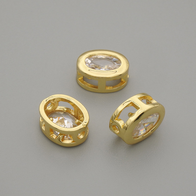 Bead insert with white crystal, gold-tone metal, oval, 9x7 mm ± hole 1.3 mm, per piece