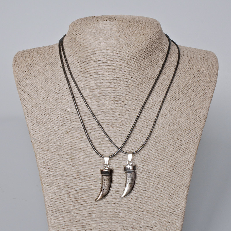 Twin pendants 'Fang' with black enamel and silvery metal, 35×12 mm; length 45–50 cm